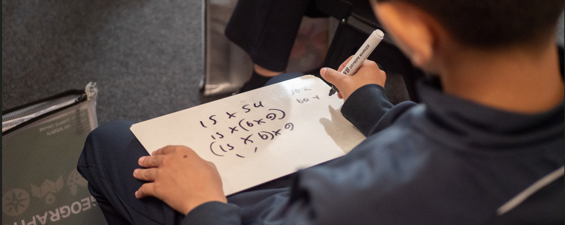 image of a pupil writing on a whiteboard
