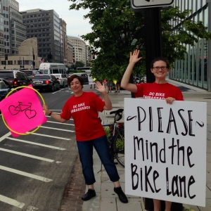 WABA Bike Ambassadors waving signs near bike lane